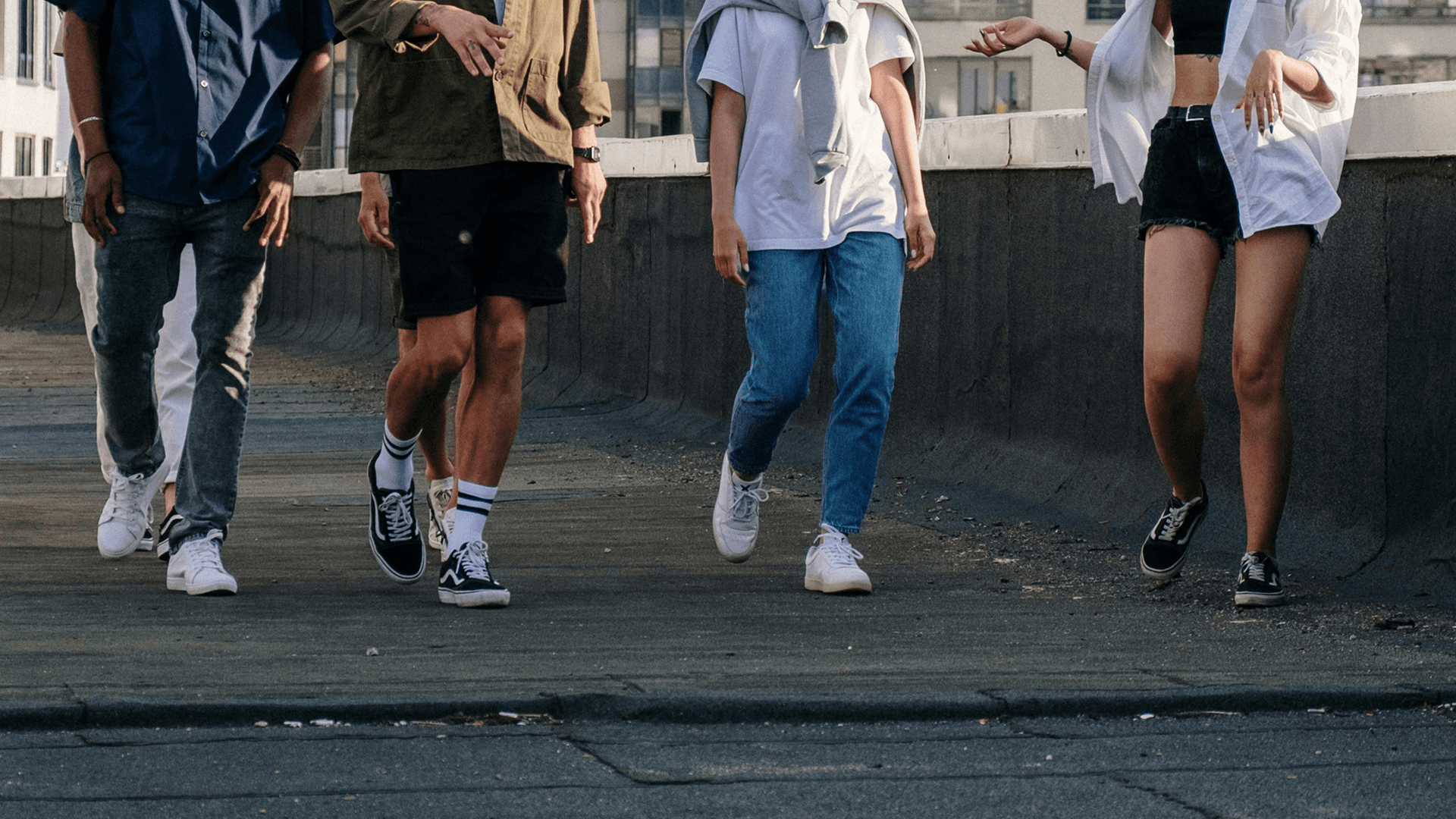 Close-up of friends' legs walking along path